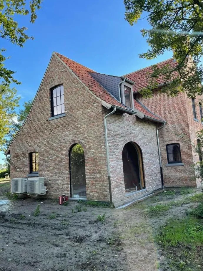 Twee buitenunits naast een nieuwbouwwoning in baksteen