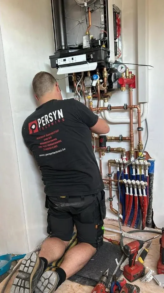 Technieker van Persyn Technics aan het werk aan een wandketel
