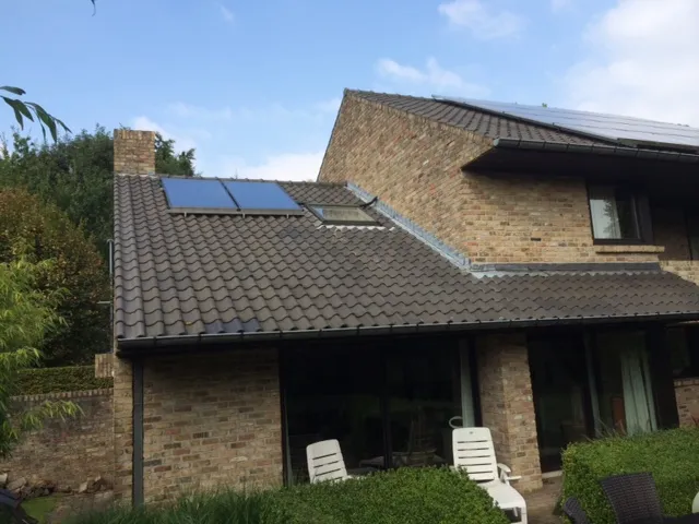 Zonneboiler met collectoren op de dakpannen van een woning